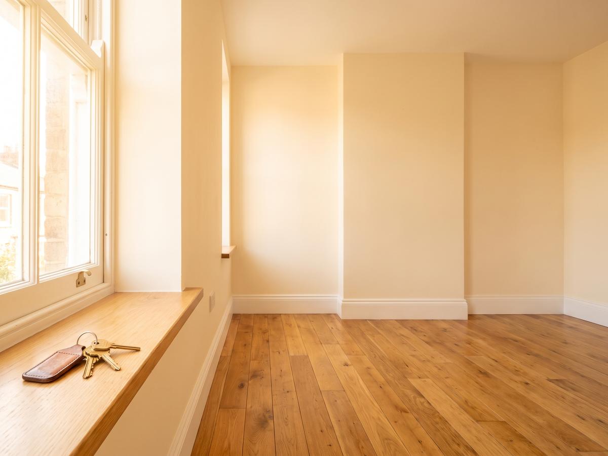 Empty freshly painted room with clean floors and keys on the windowsill
